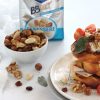 su un tavolo bianco, piatto in ceramica con french toast con salvia e pomodorini accanto a pack bbmix benessere e ciotolina con frutta secca sgusciata mista