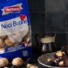noci in guscio ventura in busta e sgusciate e budino al cicocolato su piatto bianco