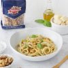 noci sgusciate ventura in busta e piatto di pici con basilico bottiglietta di olio ciotola con formaggio stagionato a cubetti