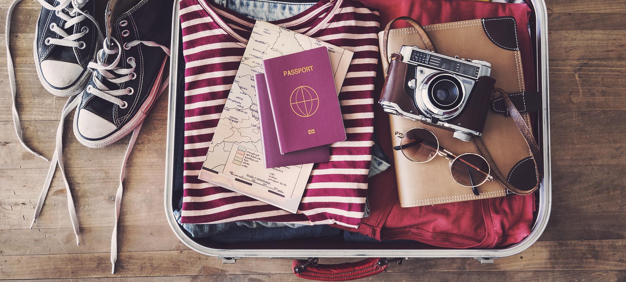 contenuto valigia passaporto macchina fotografica vintage occhiali da sole
