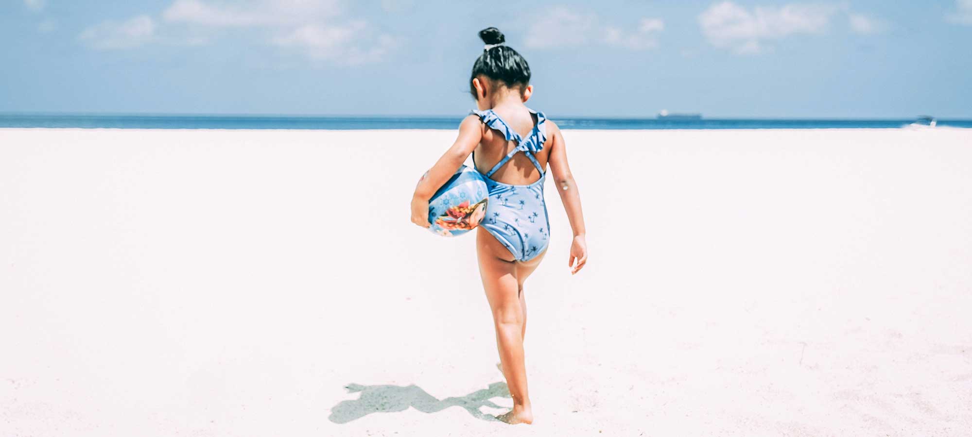 bambina al mare di spalle pallone orizzonte mare spiaggia