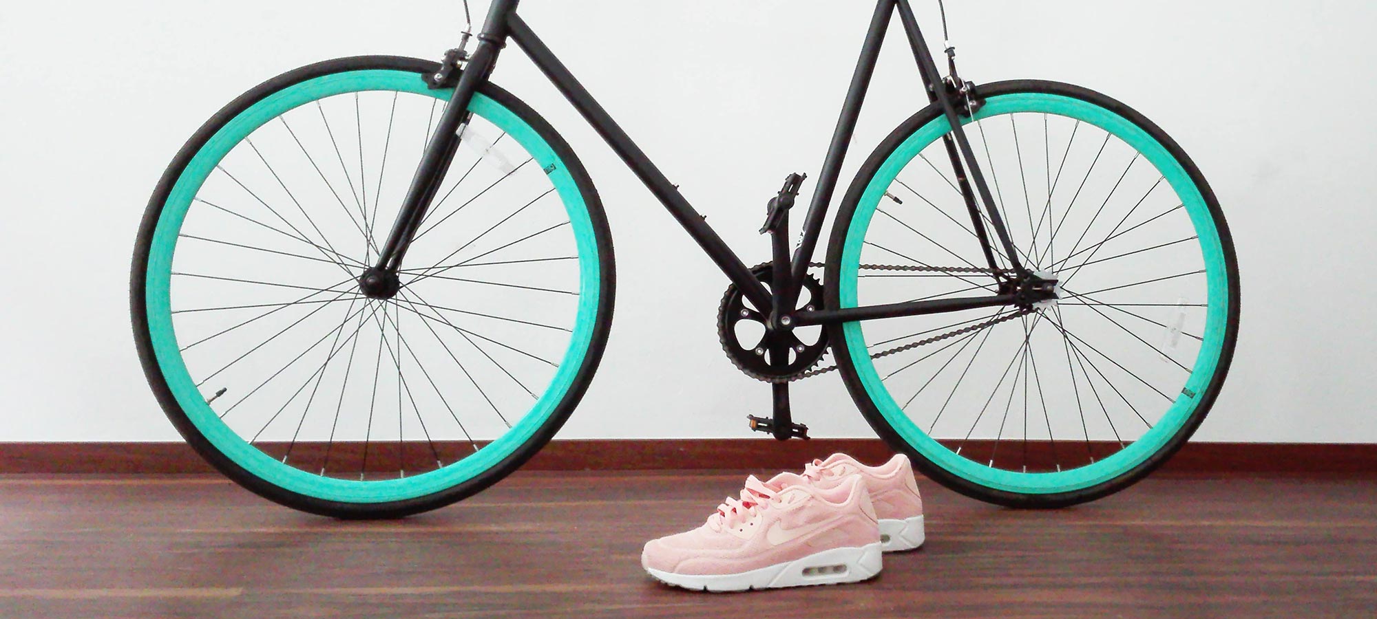 bicicletta con cambio scarpe da corsa rosa parquet