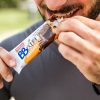 giovane uomo con barba apre coi denti confezione barretta bbextra ventura mandorla cioccolato