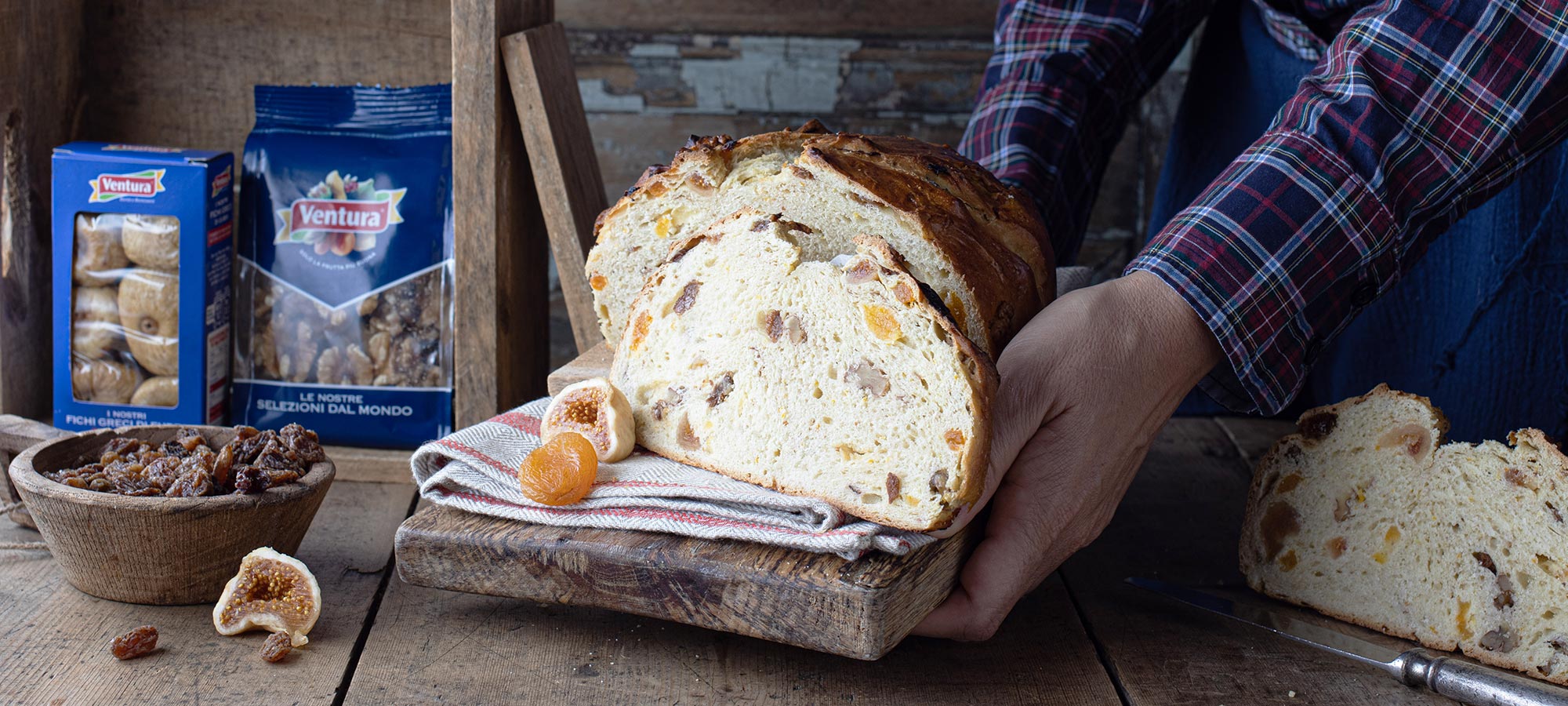 panfrutto trentino con frutta secca mani di donna camicia a quadretti fichi secchi albicocche essiccate tagliere di legno